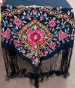 A black silk embroidered shawl, with central pink flower surrounded by floral border and further