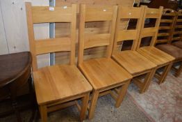 Set of four modern light oak hard seated dining chairs
