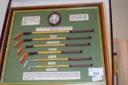 A framed display of miniature golf clubs