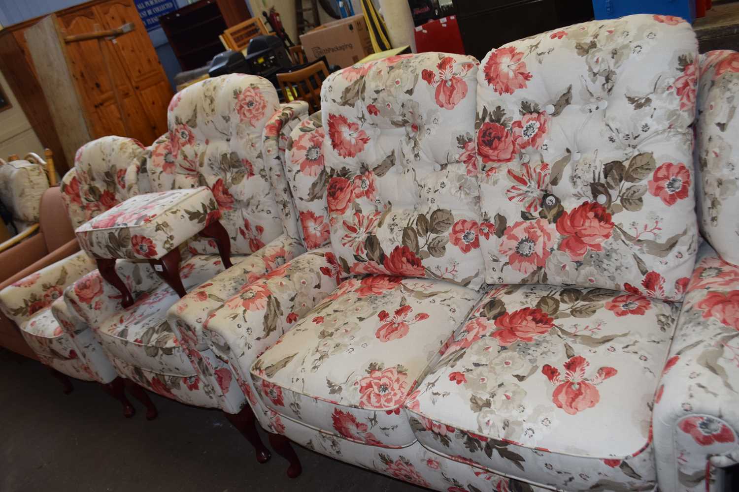 A floral upholstered three piece suite comprising two seater sofa, and armchair and a smaller wing