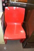 Set of three red plastic Italian stacking chairs