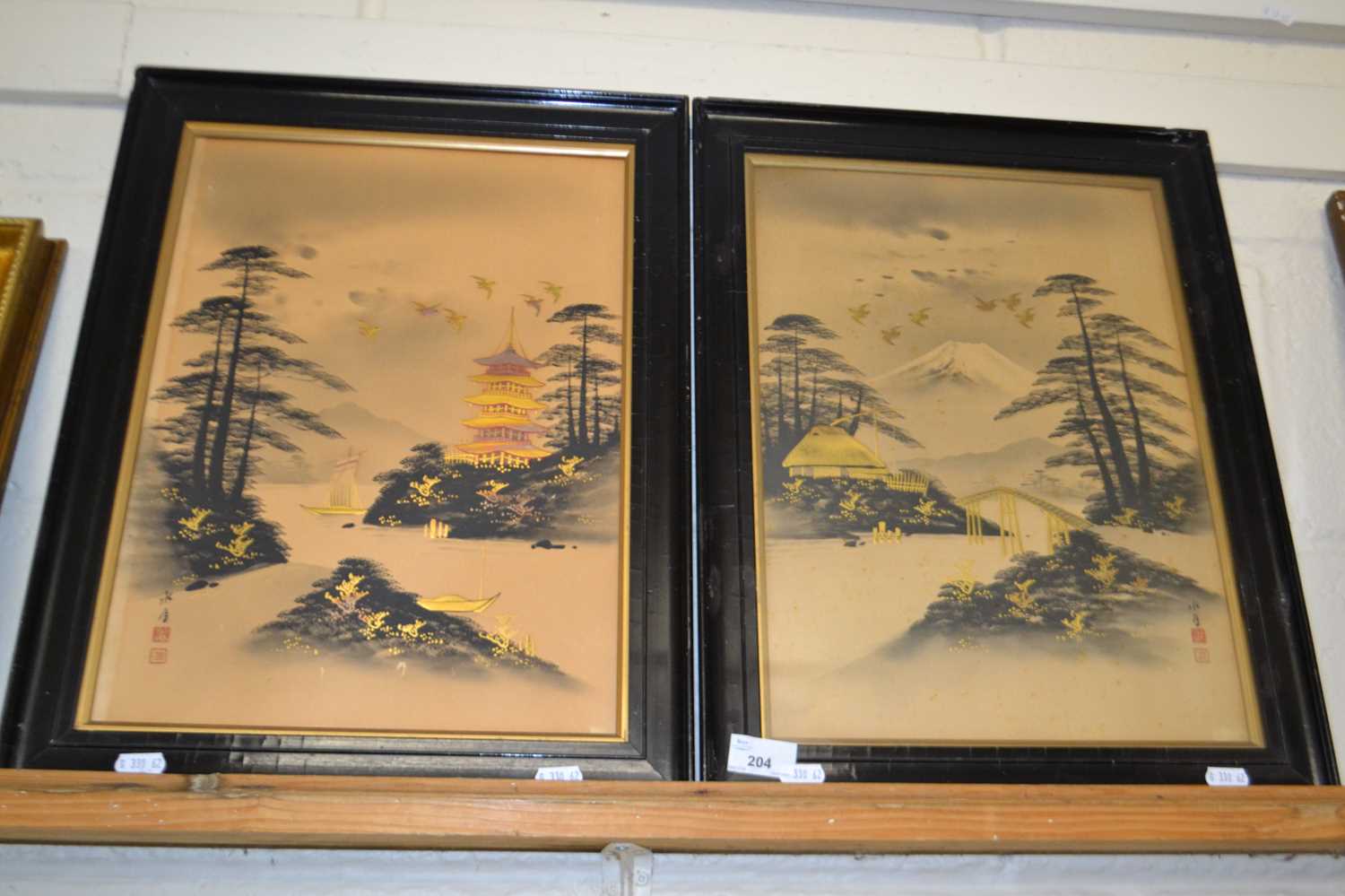 Pair of early 20th Century Japanese gilt highlighted prints, lake scenes set in ebonised frames