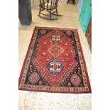 Small 20th Century Middle Eastern wool floor rug decorated with a large central red panel
