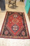 Small 20th Century Middle Eastern wool floor rug decorated with a large central red panel