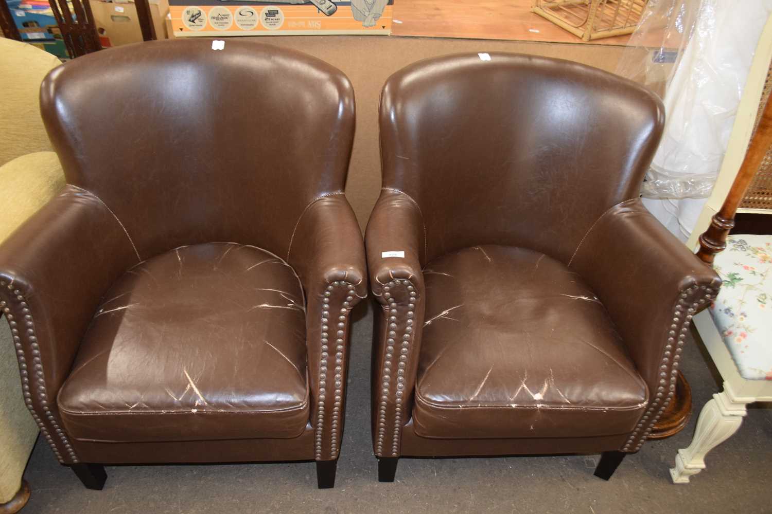 Two brown faux leather tub chairs