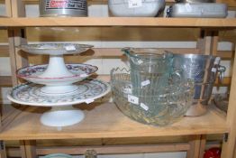 Three ceramic cake stands together with an aluminium ice bucket, glass jug and bowl