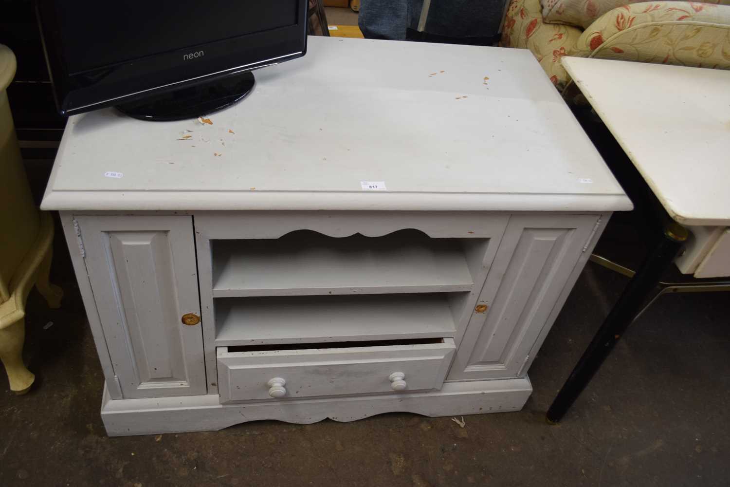 A grey painted low sideboard, cupboards to either side, shelves and drawer to centre