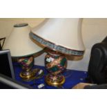 A near pair of patterned terracotta lamps with brass bases and cream shades