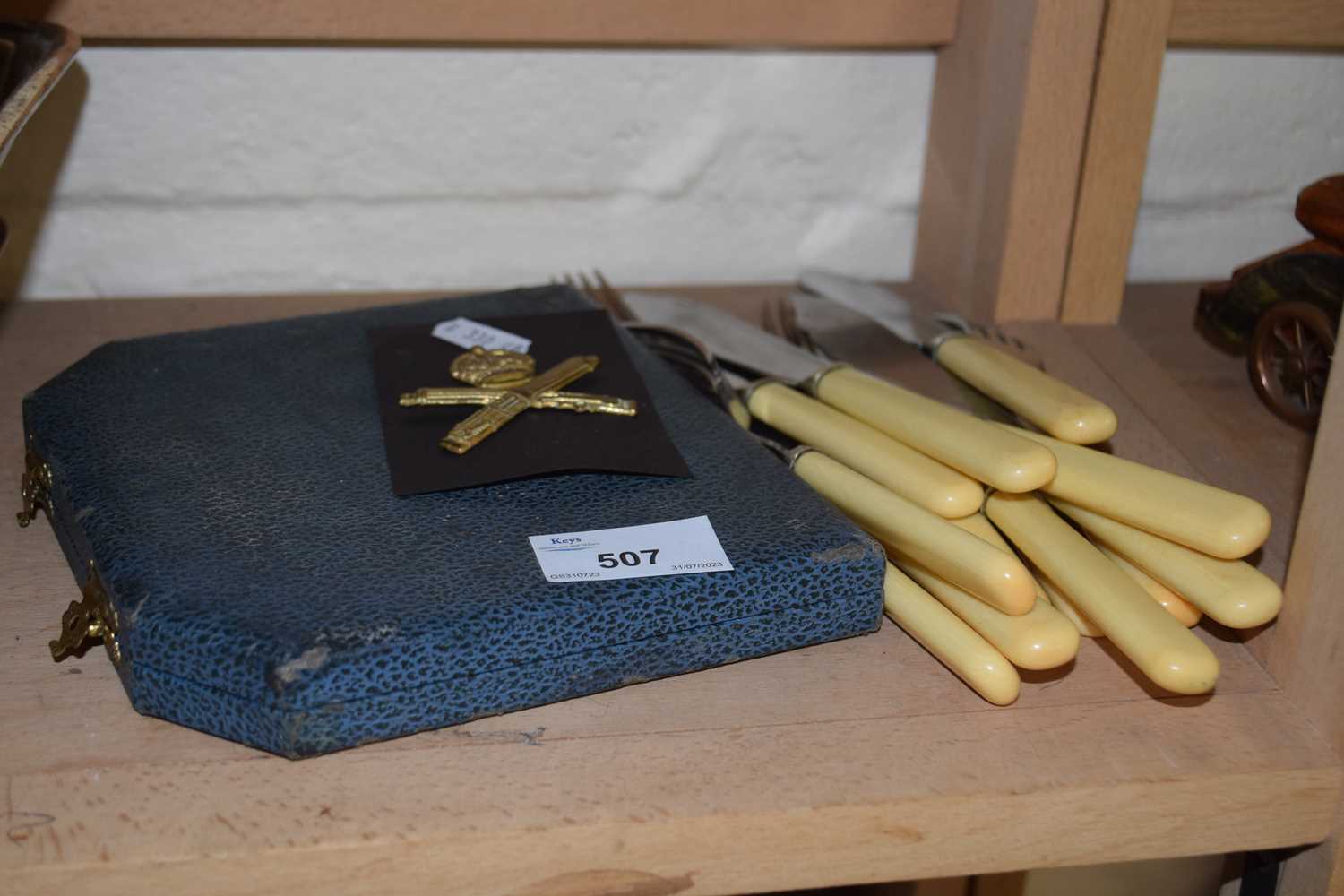 Assorted quantity of flat ware together with a cap badge