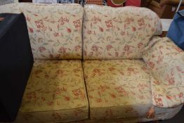 Two seater floral upholstered sofa on turned legs and casters