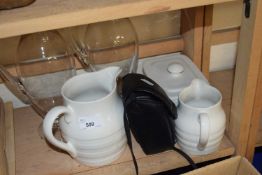 Two glass carafes together with two jugs, butter dish and a camera