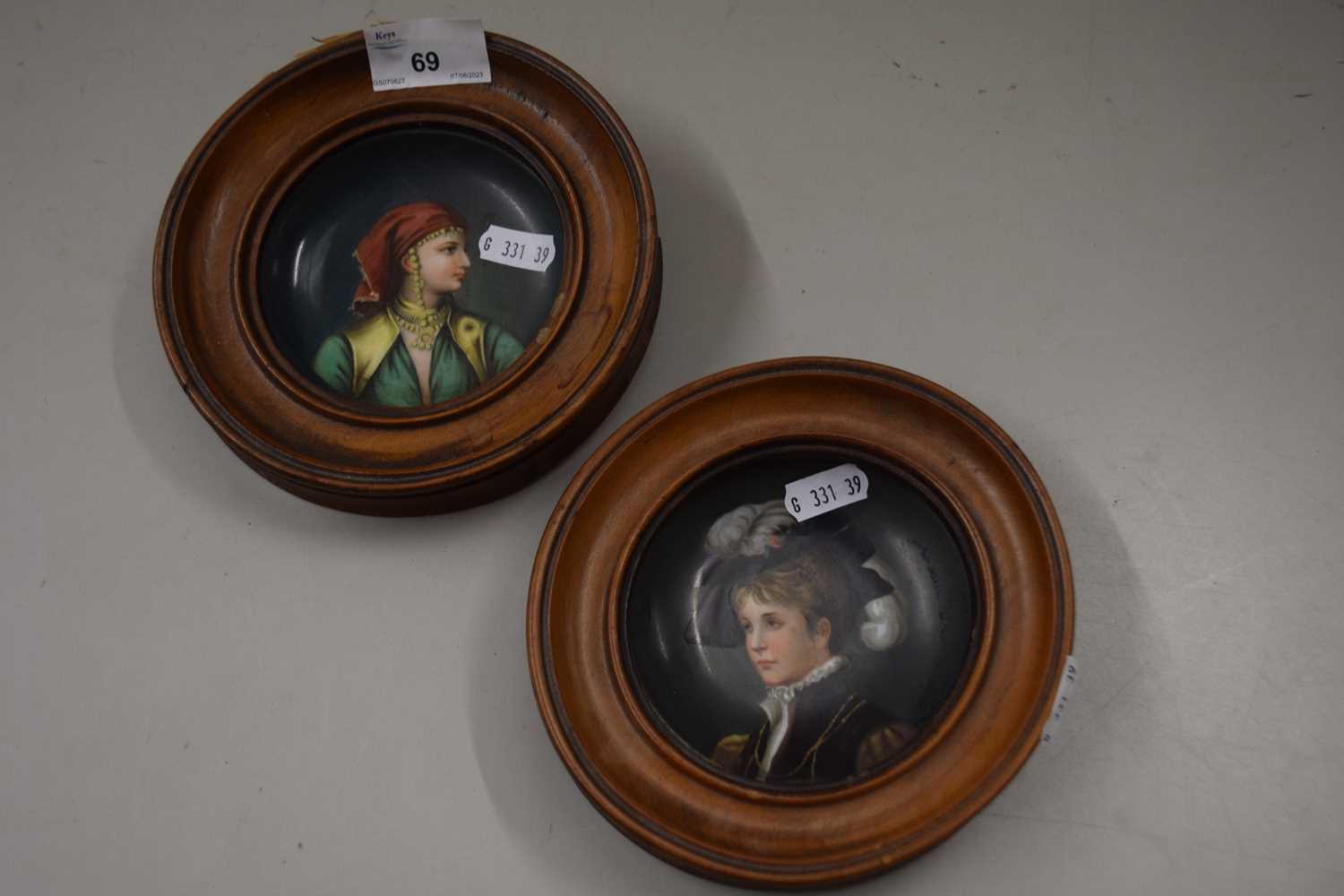 A pair of small painted saucers mounted in hardwood frames