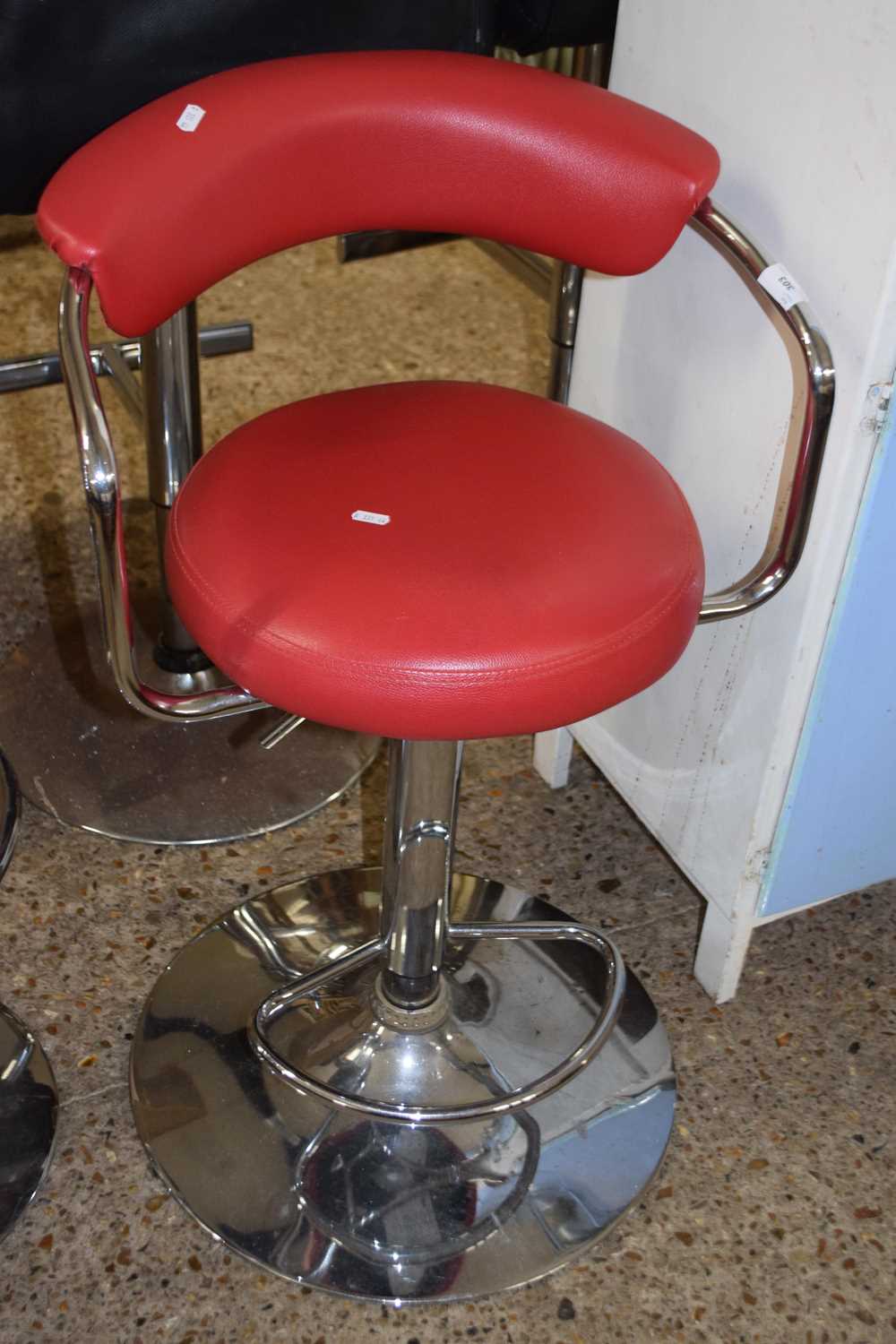 Red upholstered bar stool with cushioned back