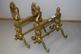 A pair of brass fire dogs with floral decoration