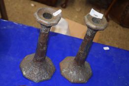 A pair of Chinese alloy candlesticks decorated with flowers and dragons