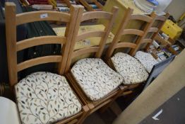 Four pine chairs with cushions and straw seats