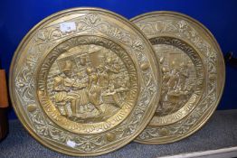 A pair of pressed brass wall plaques