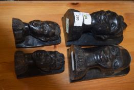 Group of four African ebonised carved heads as book ends