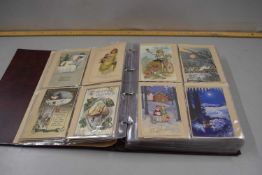 An album containing a collection of pictorial greetings cards to include a range of various