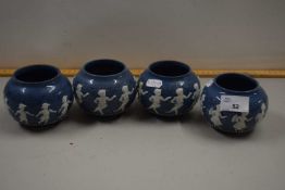 A set of four small Doulton circular vases decorated with dancing figures