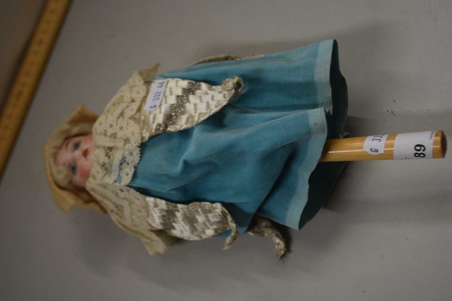 An unusual antique porcelain headed revolving doll with musical movement, 30cm high
