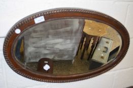 Early 20th Century oval wall mirror in a dark oak frame