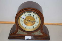 An early 20th Century mantel clock set in an arched inlaid case