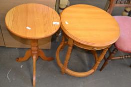 Three legged round pine side table together with another