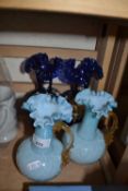 Pair of pale blue glass jugs and a pair of dark blue and painted glass vases