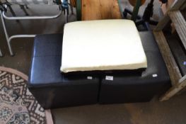 Two black upholstered stools together with an adjustable footstool
