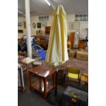 Yellow parasol and stand together with a grey storage box footstool
