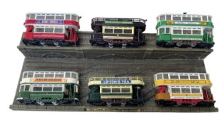 A collection of die-cast Corgi tram models on 00 gauge 1/76 diorama display plinth.