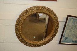 Circular wall mirror in a gilt finished plaster frame