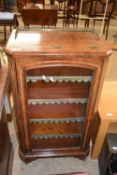 Victorian walnut veneered music cabinet with single glazed door opening to an interior with shelves,
