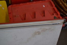 Red plastic storage container and a draftsman/artists drawing board