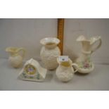 Collection of Belleek porcelain wares comprising three jugs, a mantel clock and vase