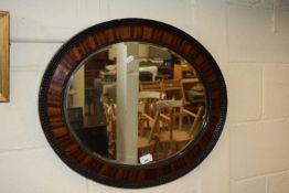 An oval framed wall mirror