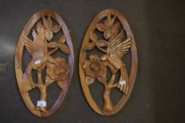 A pair of carved wooden wall plaques of humming birds