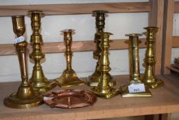 Quantity of copper and brass candlesticks and ashtrays