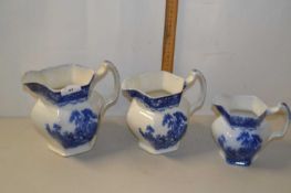 Three graduated blue and white jugs