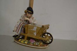 A late 19th Century John Bevington porcelain model of a gentleman holding a wheelbarrow