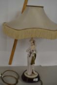 A continental porcelain lamp with a Capodimonte figure, impressed signature for B Merlin, the figure