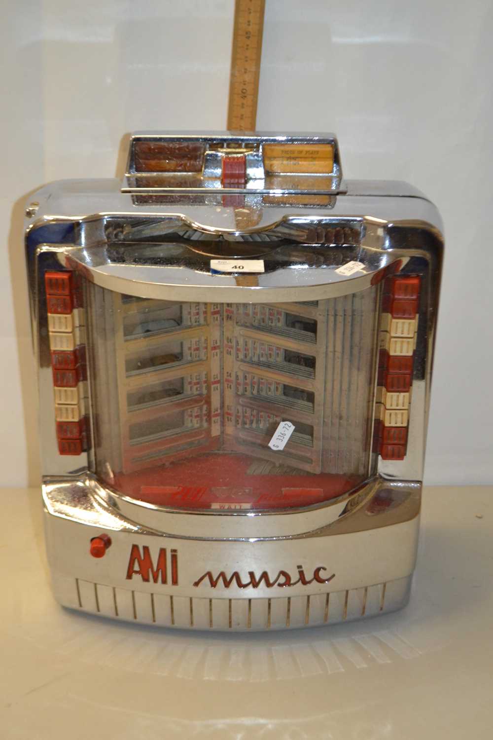 A vintage AMI Music wall mounted juke box in chrome case
