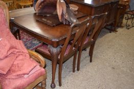 An early 20th Century walnut veneered dining room suite comprising and extending table, four