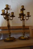 A pair of brass four branch candelabra each with inset Jasper ware roundalls