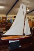 A large wooden pond yacht with cloth sales and red gloss-painted underside. Size approximately: H