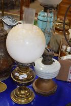Two oil lamps one with brass base the other with a milk glass font