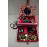 A pink jewellery box containing various assorted costume jewellery, wristwatches etc