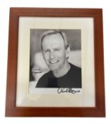 A mounted black and white photograph, bearing the signature of Paul Hogan (Crocodile Dundee) in