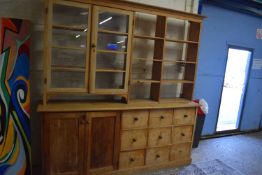 20th Century pine dresser cabinet of unusual form, the top with two glazed doors and shelved side